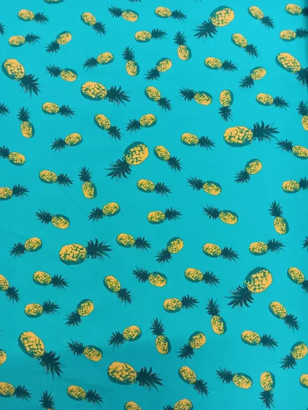 baumwolljersey-mit-ananas-motiv-verstreut-auf-einem-leuchtenden-tuerksfarbenen-hintergrund-stoff